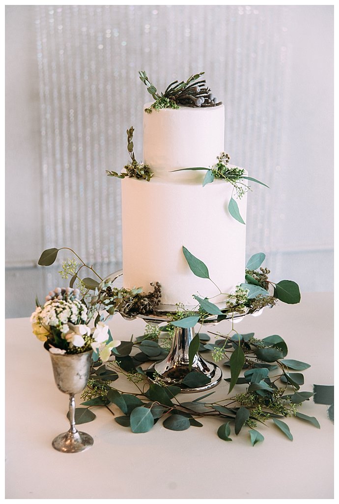 two-tiered-white-wedding-cake-eucalyptus-leaves-alyssa-ryan-photography