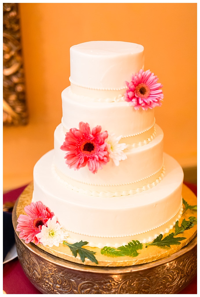 white-wedding-cake-with-pink-gerber-daisies-casey-fatchett-photography