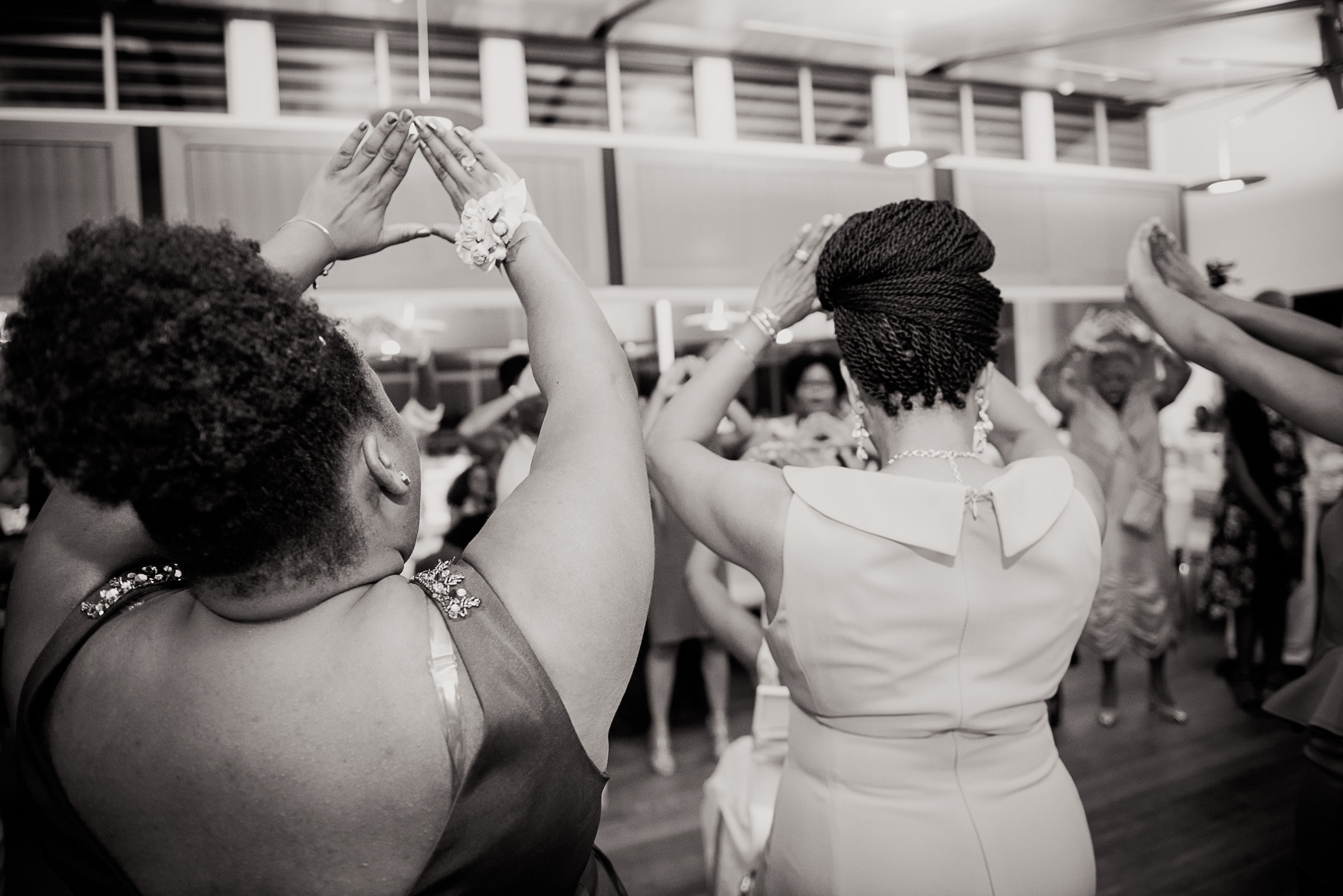 Delta Sigma Theta sorority sisters signaling to their bride sister