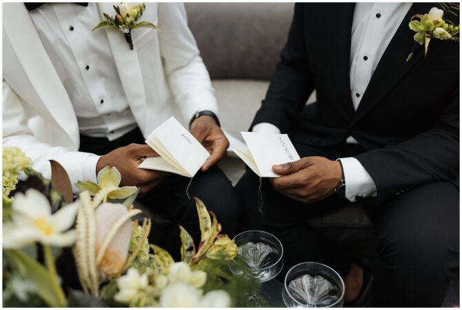 Two people exchanging vows holding notebooks, wedding attire