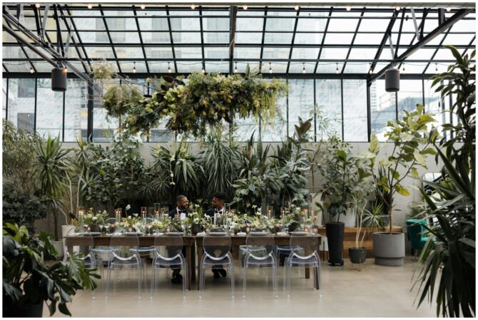 Elegant greenhouse dining setup with lush greenery.