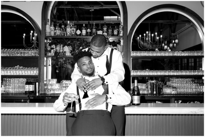 Couple embracing at a bar in black and white.