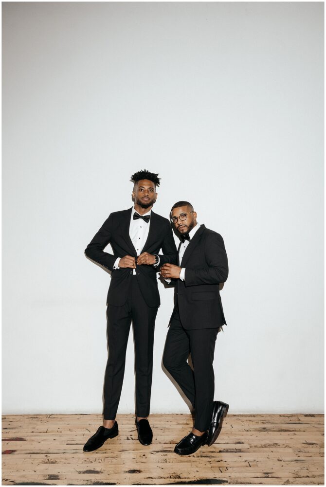 Two men in suits standing together indoors.