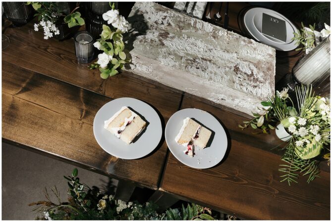 Two cake slices on wooden table with flowers.