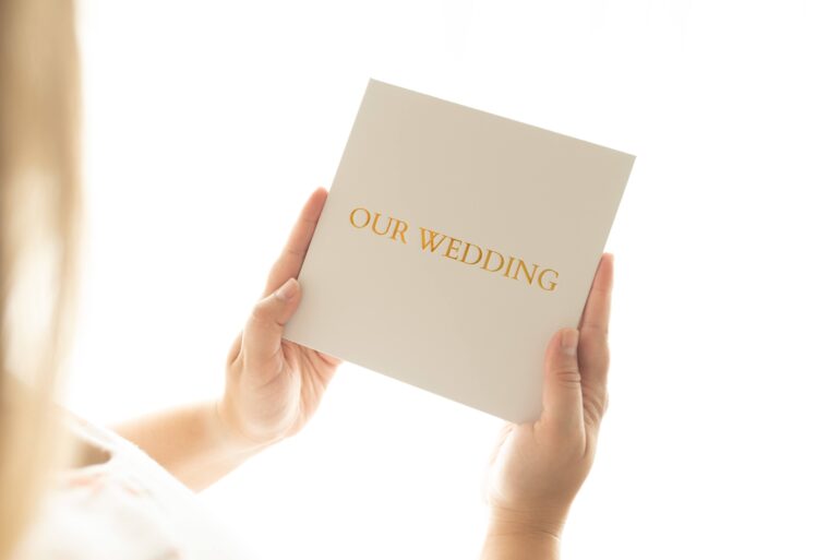 Person holding 'Our Wedding' invitation card