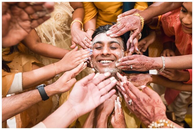 Groom smiling during traditional pre-wedding ceremony.