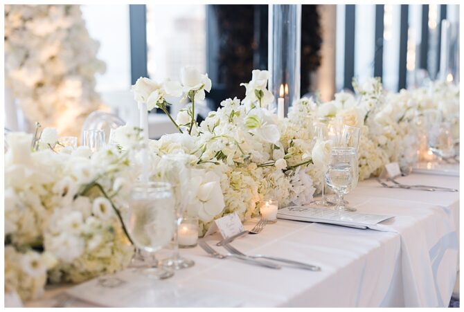 Elegant white floral wedding table decor with candles