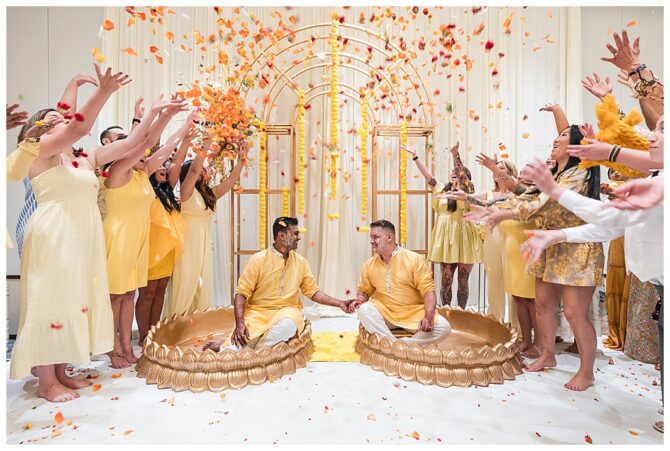 Couple in traditional ceremony with flower petals celebration.