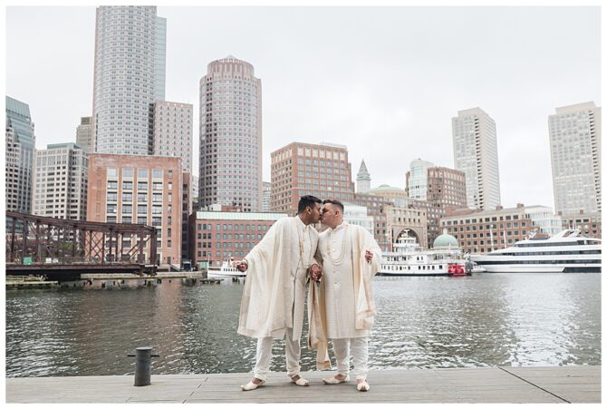 Couple kissing by waterfront skyscrapers.