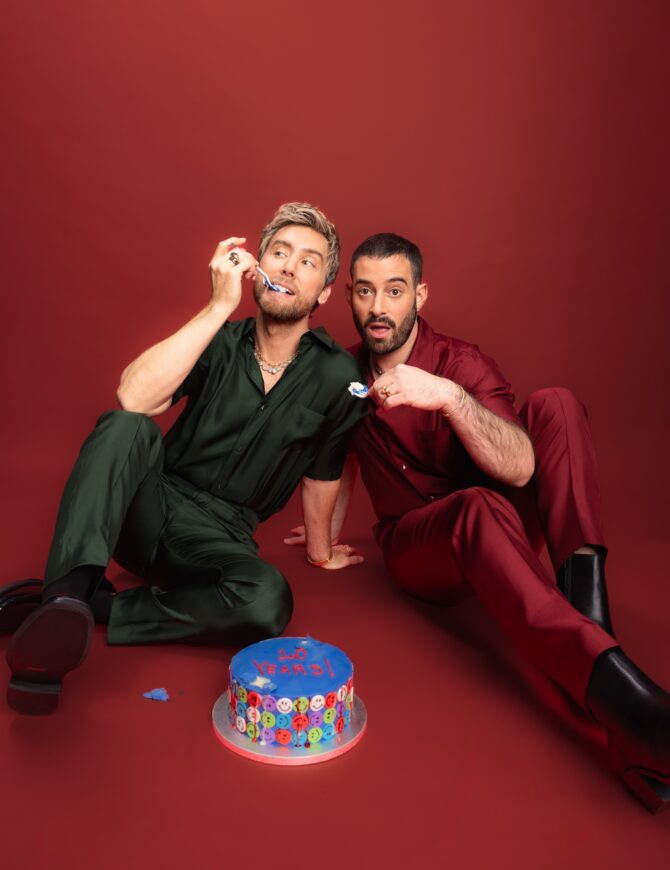 Two men celebrating with a blue cake.
