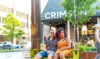 Couple sitting on swing outside cafe.