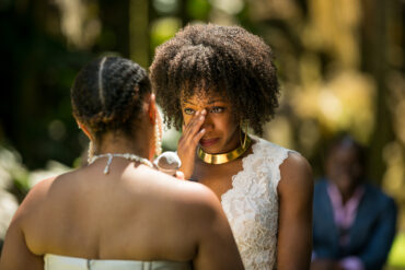 Emotional wedding ceremony with two women exchanging vows.