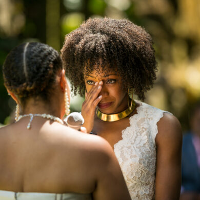 Emotional wedding ceremony with two women exchanging vows.