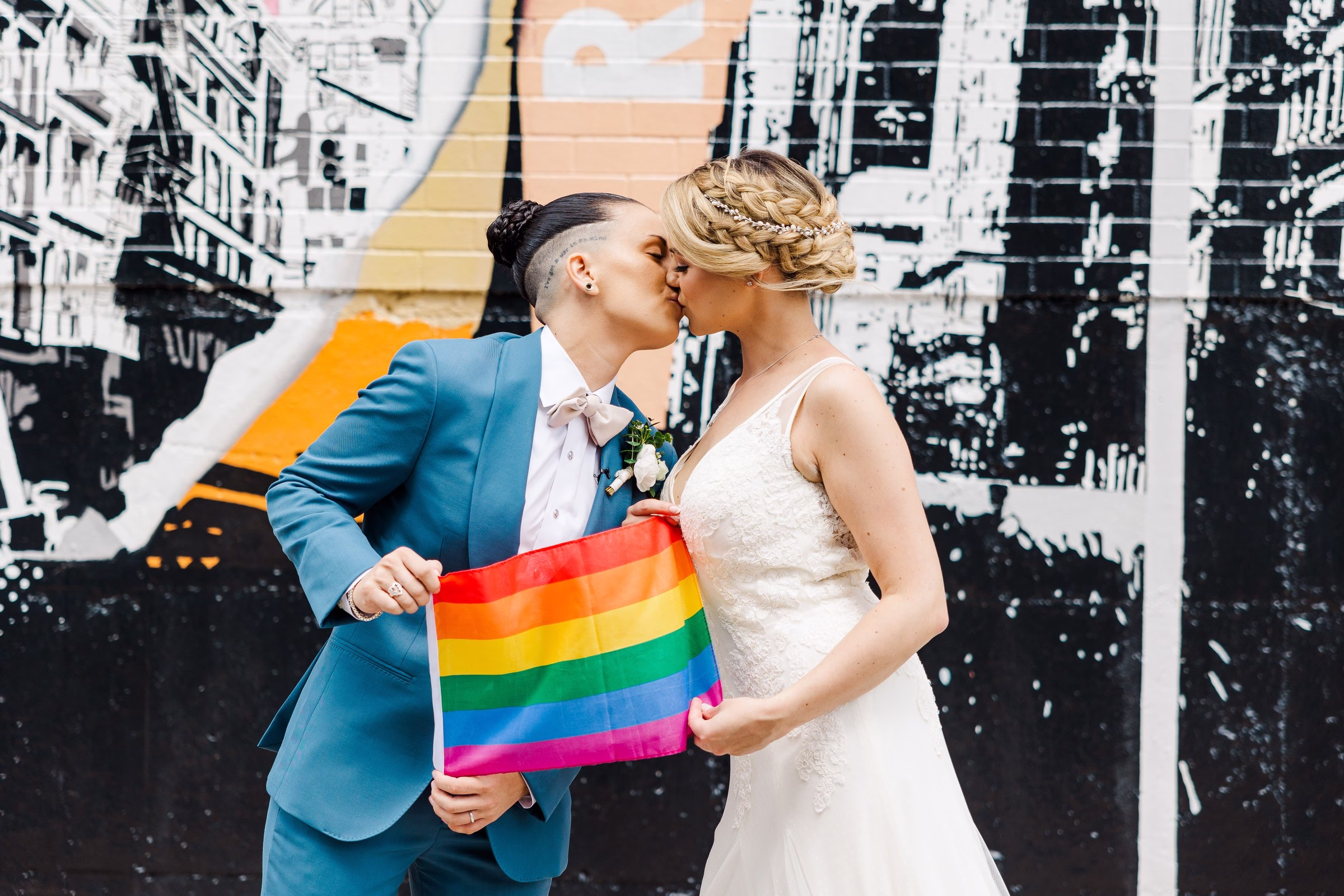 lgbtq wedding two brides pride flag kiss celebration